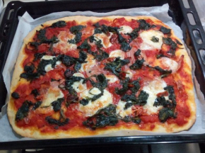 Pizza margherita con spinaci, prosciutto e pomodori secchi