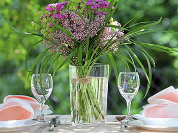 Decorazione in stile naturale: fiori e muschio a bordo tavolo
