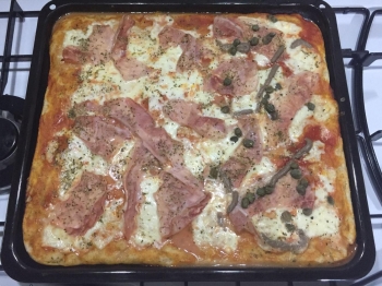 Pizza integrale al prosciutto cotto, capperi e acciughe
