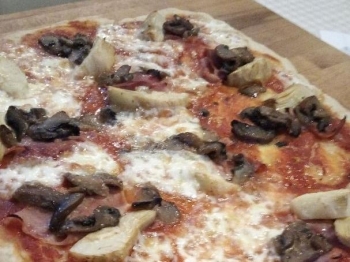 Pizza con prosciutto cotto carciofi e funghi