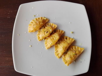 Ravioli ai gamberi con burro, timo e pistacchi