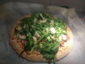 Pizza integrale con rucola pomodorini e scaglie di parmigiano