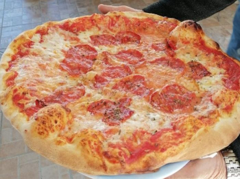 Pizza con salamino piccante nel forno a legna